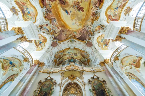 Beautifully decorated church ceiling in Baroque style with detailed frescoes and golden ornaments,
