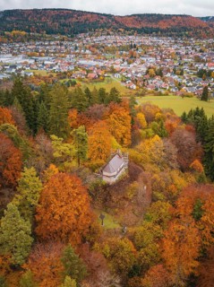 Viewing platform in an autumn forest with a view of a village below, Wehingen, Tuttlingen district,