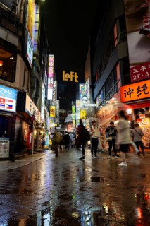Busy pedestrian zone with many shopping centers and stores, illuminated with lots of neon signs at