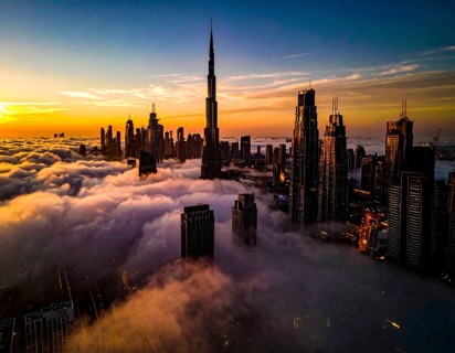 City scape emerging from a dense enveloping fog in sunrise and skyscrapers piercing the haze, big