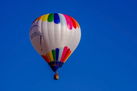 A hot air balloon, registration D-OÖJ, rises into the air as part of an air show at the