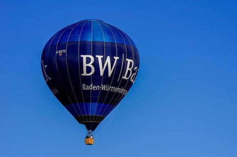 A hot air balloon, registration D-OSTC, rises into the air as part of an air show at the Rossfeld