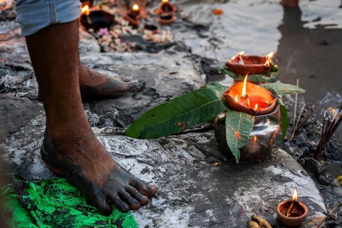 A Hindu devotee offer prayers to the Sun God on the bank of Brahmaputra river on the occasion of