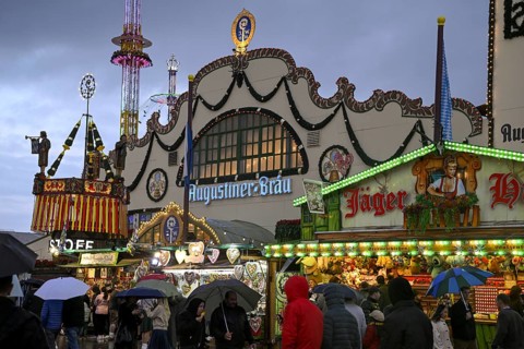 Oktoberfest visitors with umbrellas, rainy meadows, Augustiner festival tent, Munich, Bavaria,