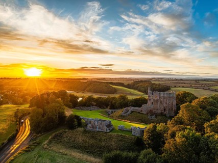 Sunset over Norham Castle and River Tweed from a drone, Norham, Northumberland, England, United