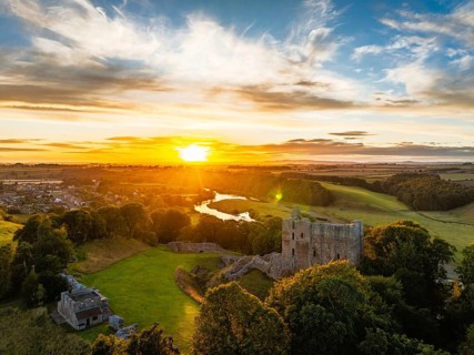 Sunset over Norham Castle and River Tweed from a drone, Norham, Northumberland, England, United