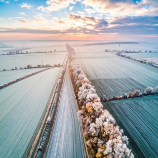 Bird Eye Perspective of Frost Covered Farmland. Seasonal Agricultural Scenery, winter and autumn