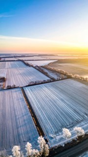 Bird Eye Perspective of Frost Covered Farmland. Seasonal Agricultural Scenery, winter and autumn