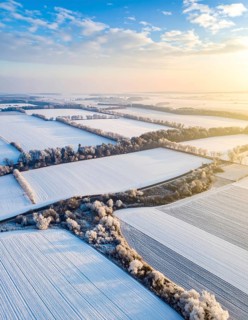 Bird Eye Perspective of Frost Covered Farmland. Seasonal Agricultural Scenery, winter and autumn