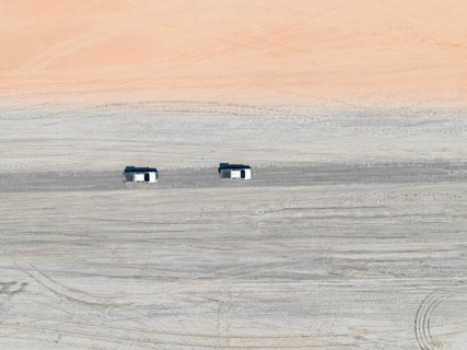 Aerial view, top-down view, two off-road cars driving on a road in arid countryside, Botswana