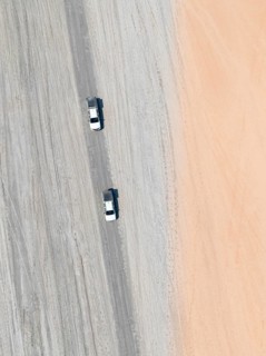 Aerial view, top-down view, two off-road cars driving on a road in arid countryside, Botswana