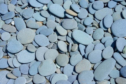 Close-up of smooth grey stones on the beach, Tuhawaiki Point Lighthouse or Jack's Point Lighthouse,