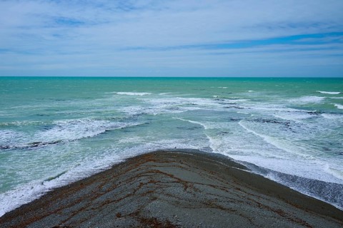 Sea with foaming waves and cloudy sky, Tuhawaiki Point Lighthouse or Jack's Point Lighthouse,