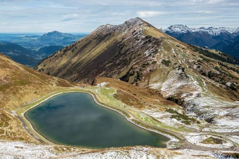 Reservoir, Kanzelwand snow-making pond, behind Fellhorn and mountains of the Allgäu Alps,