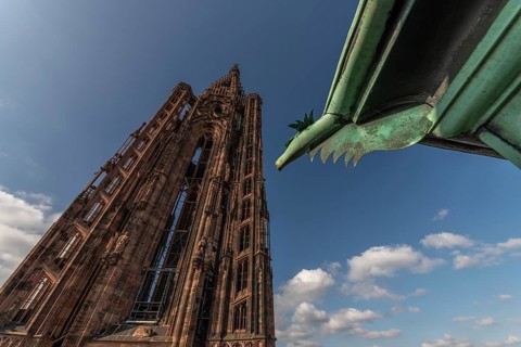 Strasbourg's Gothic cathedral stands majestically under a cloudy sky. In the background is an