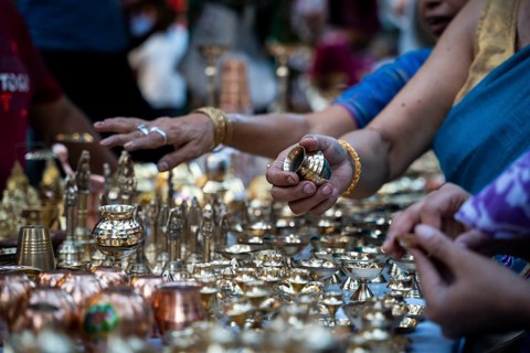 People shop for bronze and other metal items at a roadside stall on Dhanteras, in Guwahati, Assam,