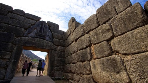 Group of visitors pass through a huge stone gate, lion gate, Mycenae, archaeological site, UNESCO