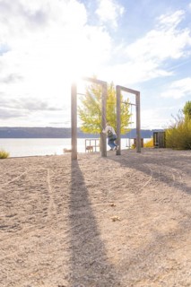 Lakeside swing with sun and long shade on the sand, Überlingen, Lake Constance, Germany