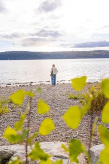Person on a pebble beach looking at the lake on a cloudy day, Überlingen, Lake Constance, Germany