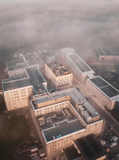 Urban industrial area seen from above in fog and dawn, new hospital health campus building, Calw,