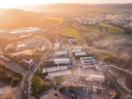 Sunrise over a village with adjacent fields and winding roads, new hospital health campus building,