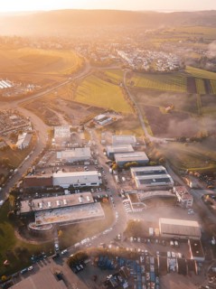 Aerial view of a village in morning light surrounded by rolling fields, new hospital health campus