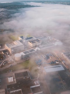 Wide landscape with industrial complex in fog from an aerial perspective, new hospital health