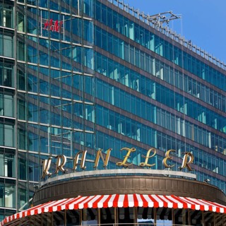 Historic Café Kranzler logo with modern office building and H&M logo on Kurfürstendamm,