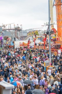 Large crowd at a lively folk festival with various rides and a lively atmosphere, Cannstatter Wasen