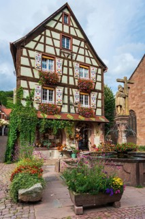 Emperor Constantin fountain in front of a half-timbered house in Kaysersberg