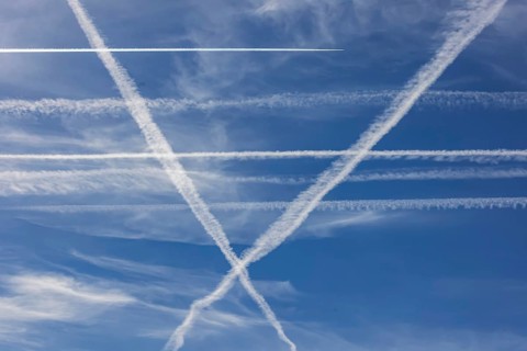 Contrails in the sky. These artificial clouds are created from the exhaust fumes of aeroplanes. But