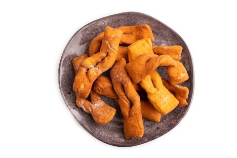 Crunchy biscuit Brushwood cookies sprinkled with powdered sugar isolated on white background, top