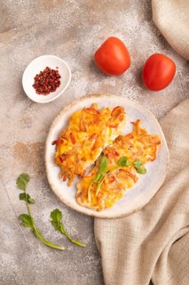 Baked chicken meat with cheese and tomatoes on brown concrete background and linen textile. top