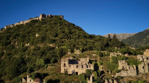 Drone image, Byzantine castle perched on a wooded hill under a blue sky, Mystras, Mistra, UNESCO