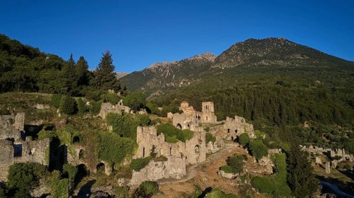 Drone shot, Historical ruins in a hilly landscape with a clear blue sky, Church of Agia Sophia from