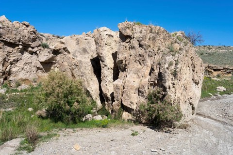 Rough rocky area with little vegetation and blue sky above, Stone Book, landscape near Dashtakar,