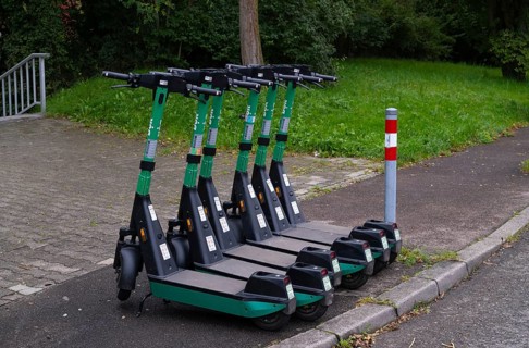 Several e-scooters, electric scooters, scooters parked on the pavement, pavement, in the Bolt bike