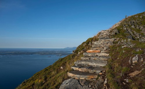 Woman walking up Rørsethornet stone stairs, with 3292 steps one of the longest continuous stone