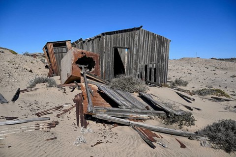 Dilapidated building in the desert sand, Pomona, restricted diamond area, near Lüderitz, Karas