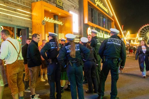 Police officers monitor the marquee area at night and ensure safety among the visitors, Cannstatter