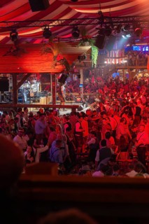 Crowded hustle and bustle in an atmospherically illuminated beer tent at the festival, Cannstatter