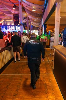 Security guard in a well-attended beer tent with festival decorations, Cannstatter Wasen folk