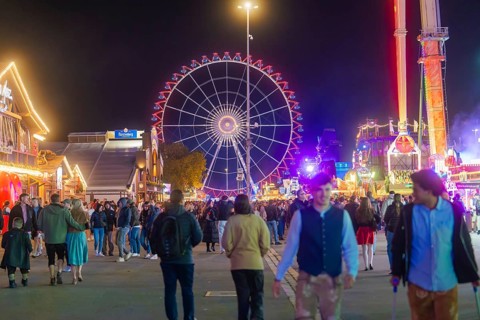 Night market with a brightly lit Ferris wheel and many visitors, Cannstatter Wasen fair, Stuttgart,