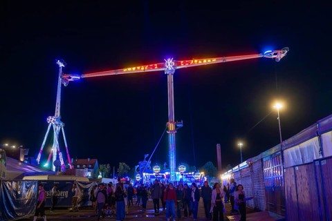 Lively funfair at night with colourful lights and many visitors, Cannstatter Wasen funfair,