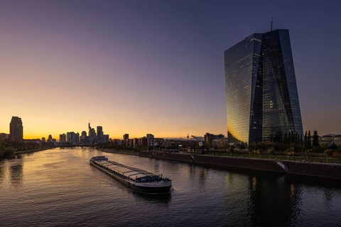 A boat cruises along the Main at sunset, in front of the European Central Bank (ECB) and the