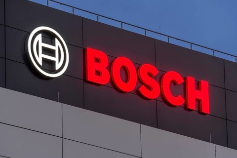 Bosch logo illuminated on the building façade against a blue night sky, Waiblingen,