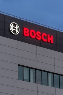 Tall grey building façade with Bosch logo and large windows at night, Waiblingen,