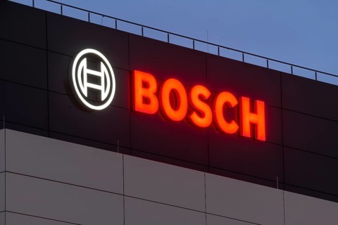 Illuminated Bosch logo on a grey façade against a blue night sky, Waiblingen, Baden-Württemberg,