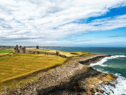 Dunstanburgh Castle from a drone, Northumberland Coast, England, United Kingdom