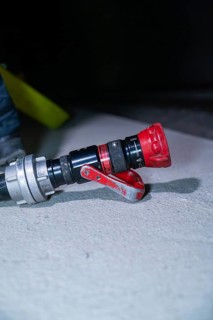 Close-up of a fire hose with a red nozzle on the ground, fire drill in the new construction tunnel